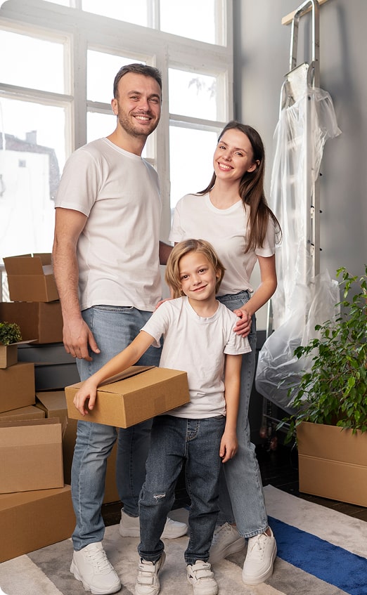 Family of four standing with moving boxes in their new home