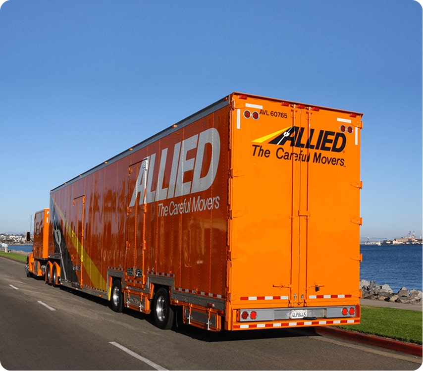 Orange Allied Van Lines moving truck driving along the waterfront
