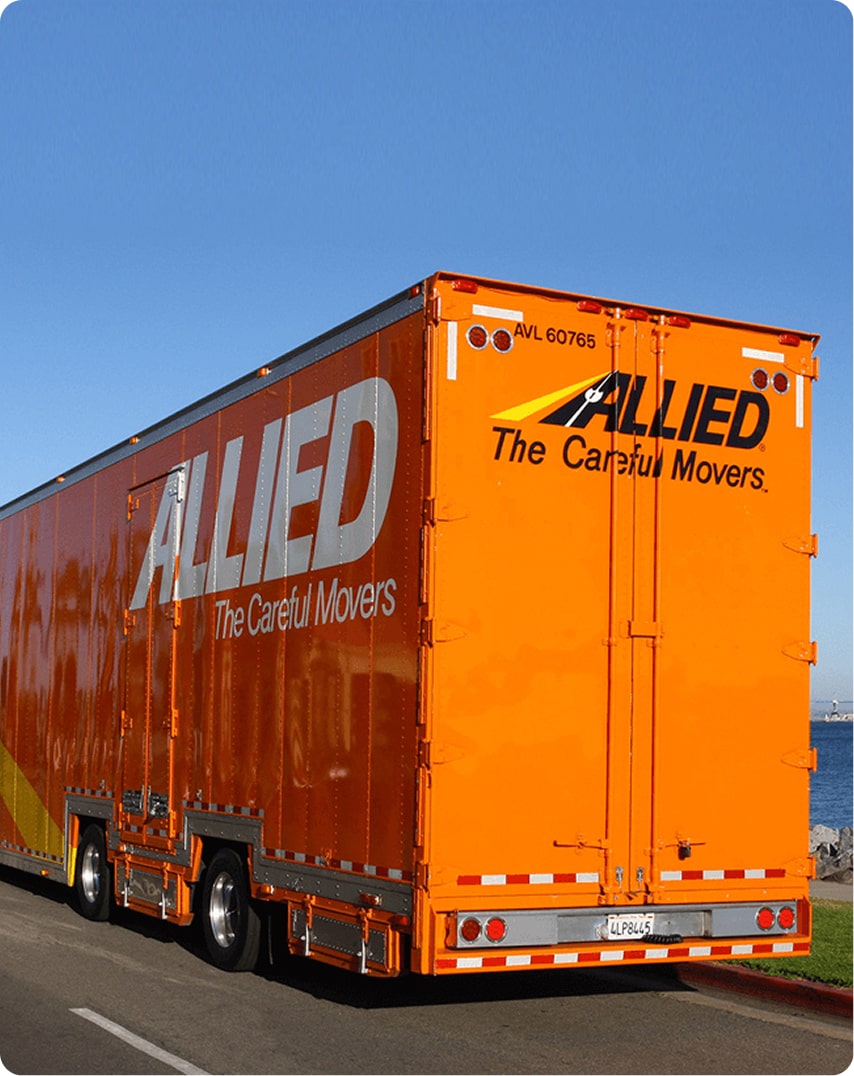 Orange Allied Van Lines moving truck driving along the waterfront