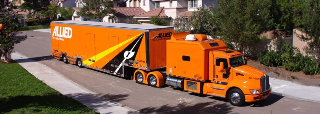 Orange Allied Van Lines moving truck driving down a residential street