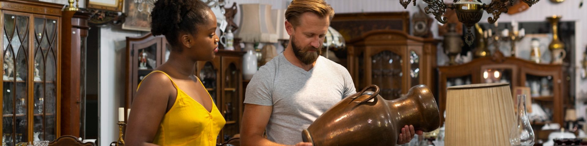 Couple examining a vase and antiques in an antique shop