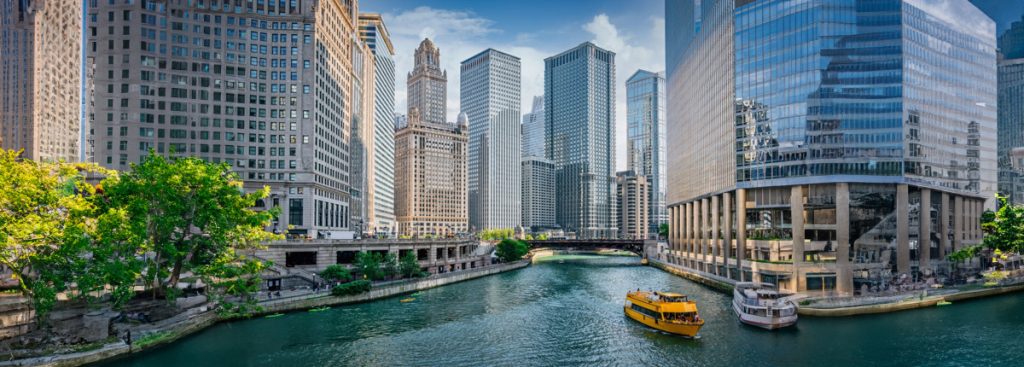 Chicago River with downtown buildings and a water taxi