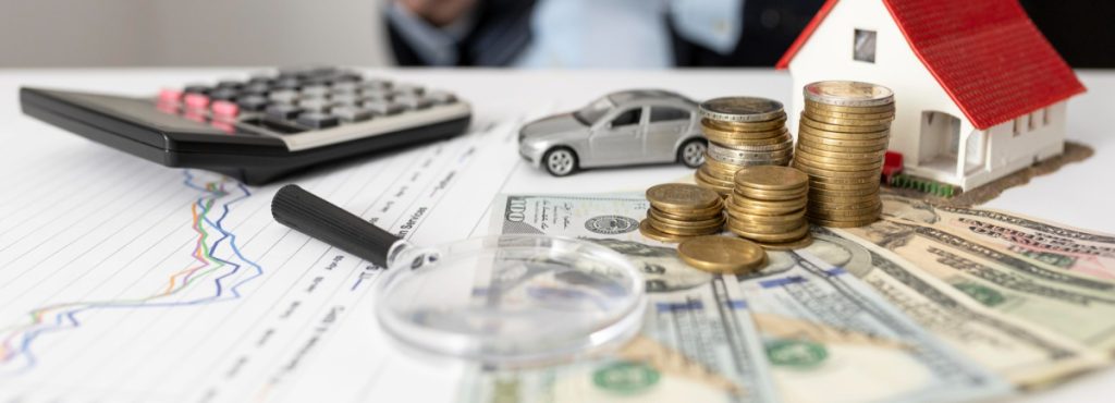 Calculator, coins, banknotes and a model house on financial charts